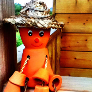 clay flower pot man illustrating a post on dealing with weeds in the garden
